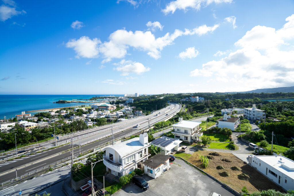 沖縄自動車道を走行する車、那覇空港からジャングリアへ向かうレンタカーアクセスの風景