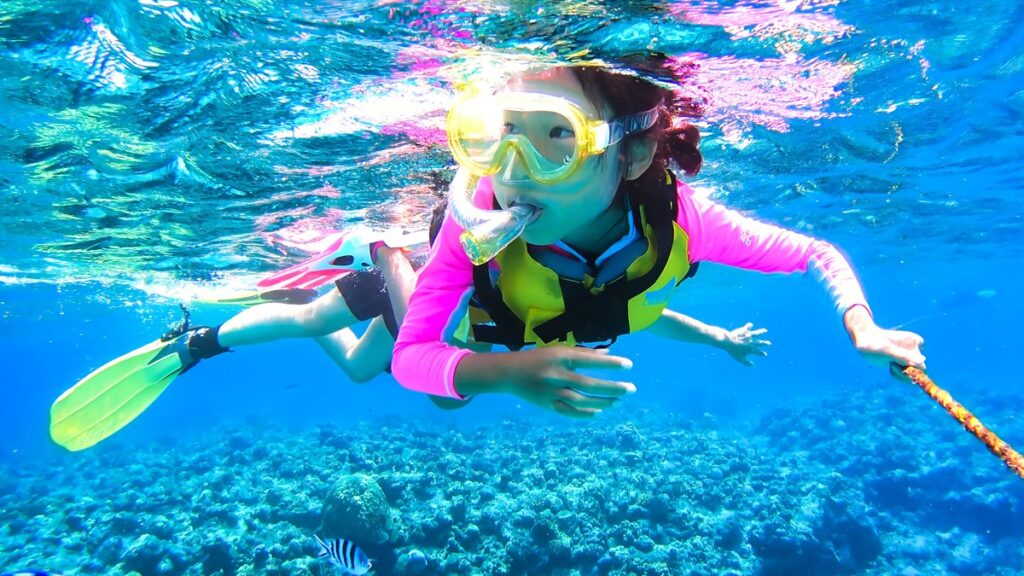 沖縄の海でシュノーケリングを楽しむ親子（イメージ）