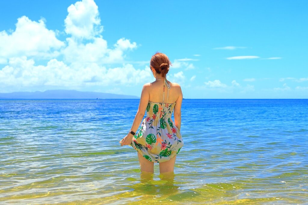沖縄のビーチリゾートで海を眺める女性（イメージ）