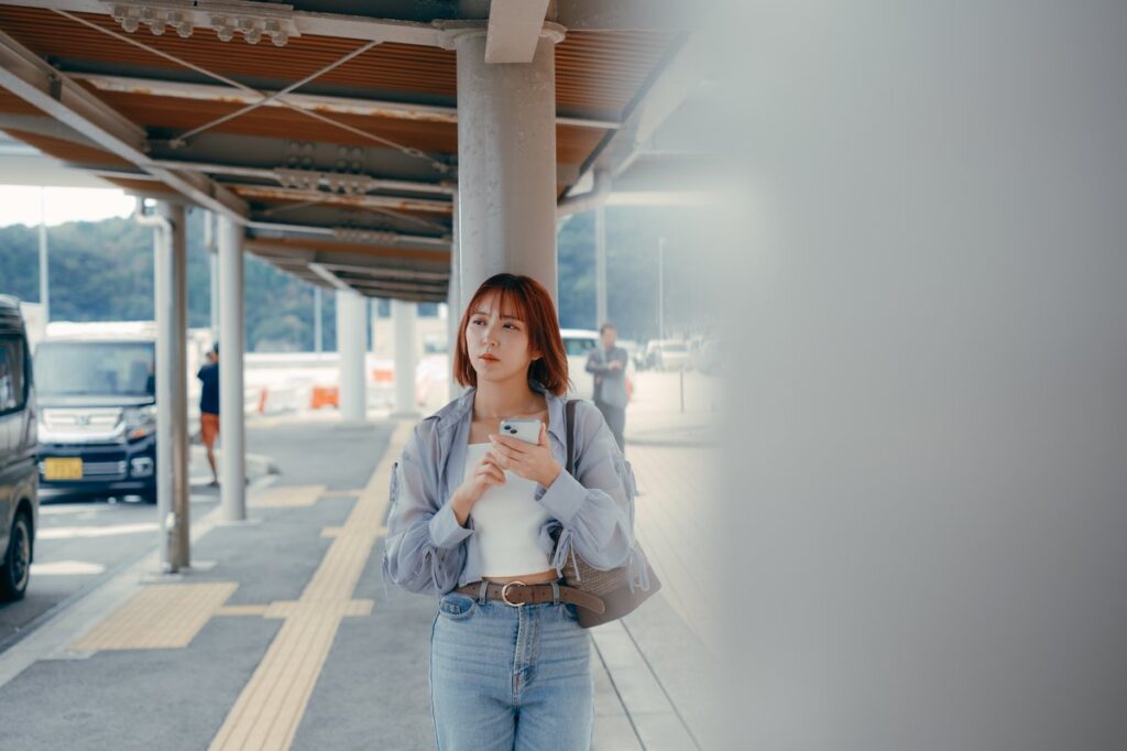 フェリー乗り場でスマートフォンを確認する女性（イメージ）