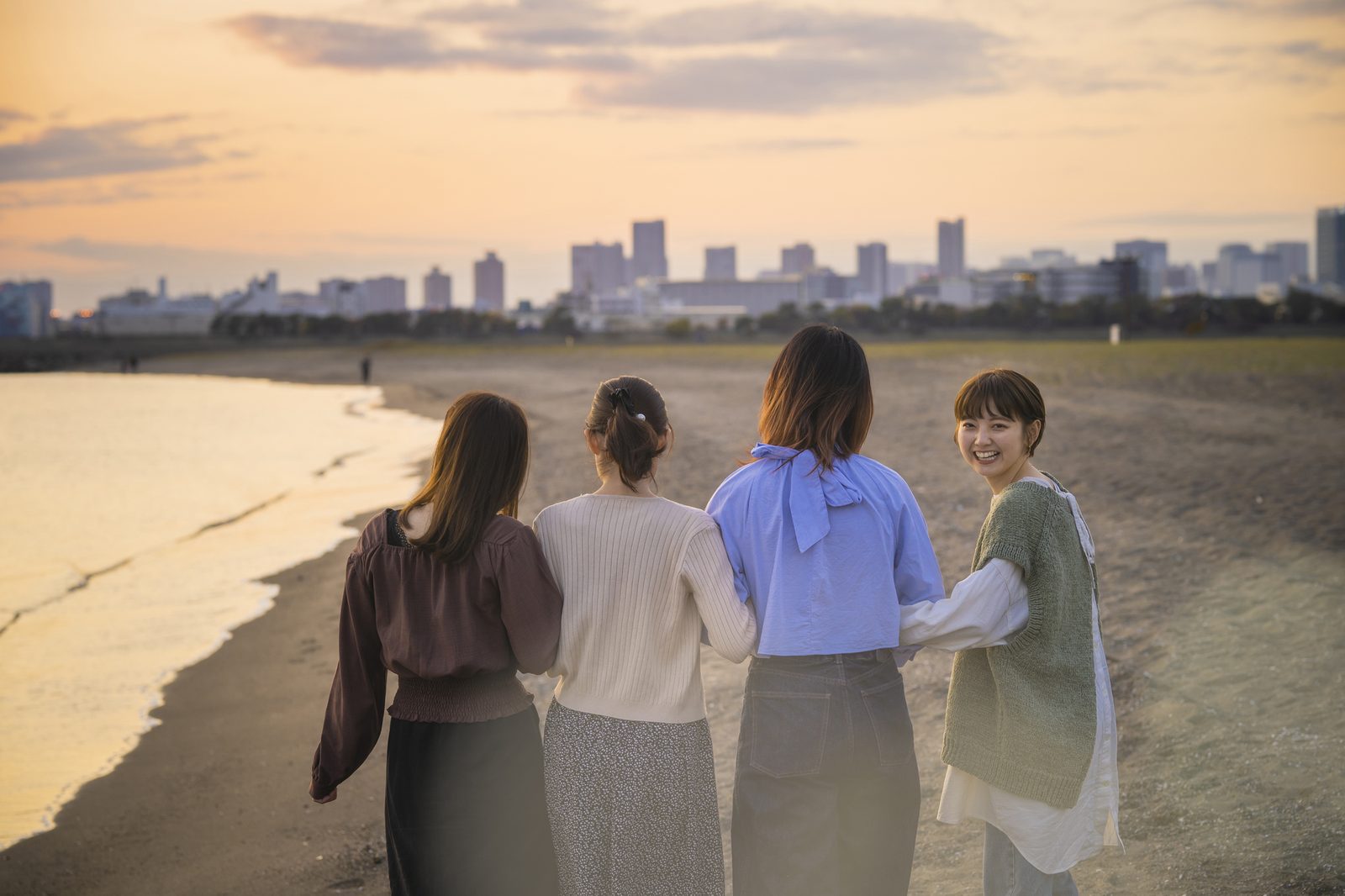 海辺を歩く旅行グループ（イメージ）