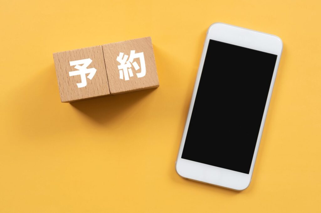 旅行予約をイメージしたスマートフォンと予約のブロック（イメージ）